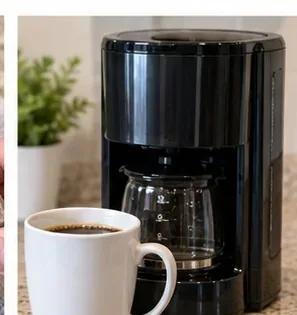 Een schoon, zwart filterkoffiezetapparaat naast een vers gezette kop koffie na het schoonmaken en spoelen.