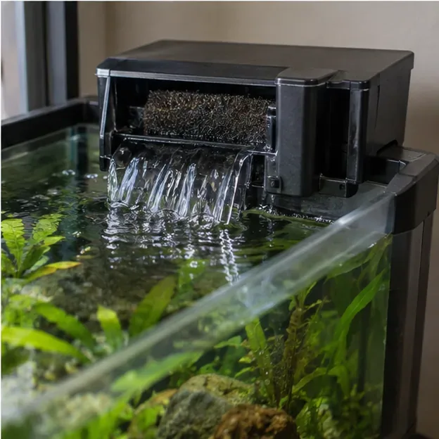 Een opnieuw gemonteerd hangfilter voor aquaria zorgt voor een constante waterstroom in een aquarium met planten.