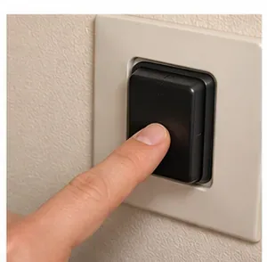 Door met de vinger op een wandschakelaar te drukken om een ​​afvalvermaler aan te zetten.