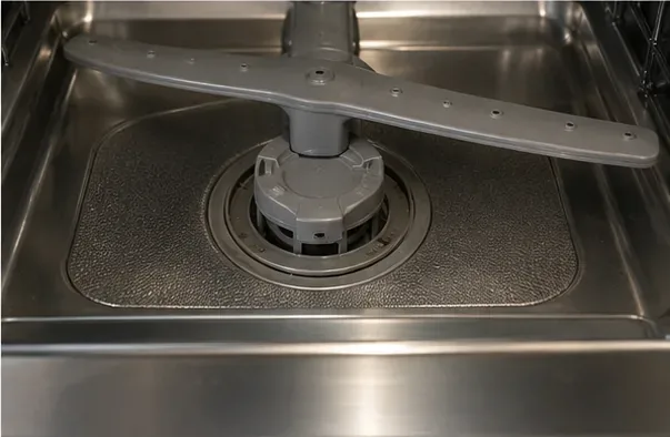 再組み立てされた食器洗い機フィルターシステムは、下部スプレーアームの下に取り付けられています。
