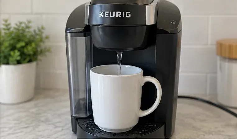 Een Keurig-koffiezetapparaat schenkt helder water in een witte mok tijdens een spoelcyclus zonder capsules.