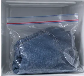 Een blauwe spijkerbroek, verpakt in een plastic zak en in de vriezer gelegd, om kauwgom te laten uitharden.