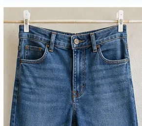 Blauwe jeans hangend aan klemmen te drogen na vlekbehandeling en wassen.