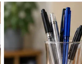 Verschillende pennen met dop of intrekbare pennen staan ​​bij elkaar in een doorzichtige bureauhouder.