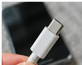 Сухой разъем кабеля USB-C проверяется перед повторным подключением к телефону.