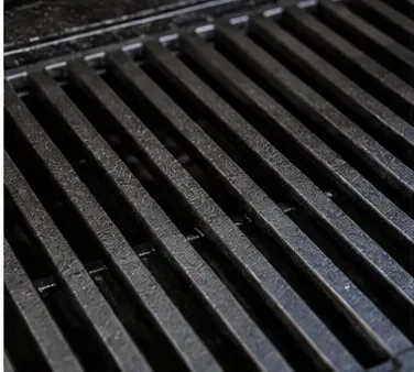 Donkere, gelijkmatig gecoate gietijzeren grillroosters na het inbranden.