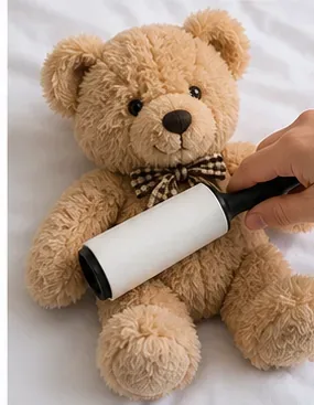 Een beige knuffelbeer wordt klaargemaakt om gewassen te worden; los vuil van het oppervlak wordt verwijderd.