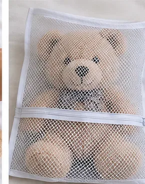 Een knuffelbeer in een waszak van gaas met ritssluiting.