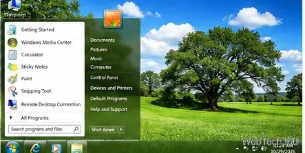 Un escritorio estilo Windows 7 inspirado en la naturaleza que muestra un árbol en un prado verde y un menú de inicio translúcido.