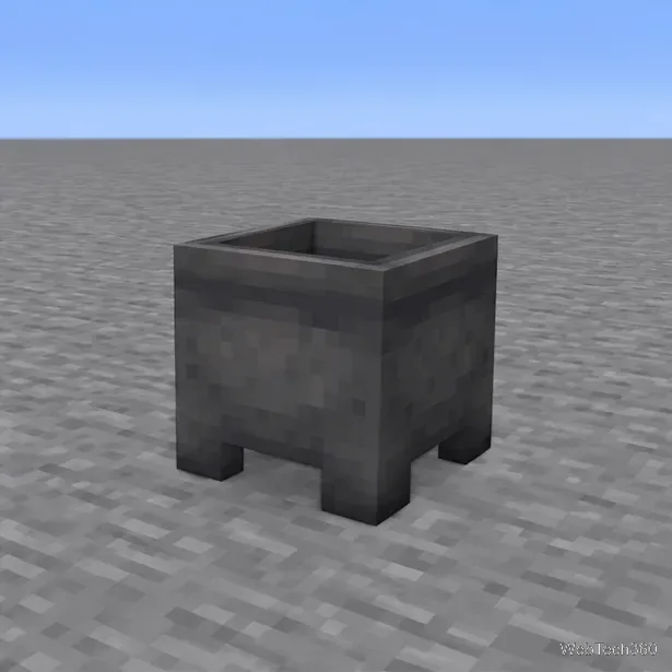 An empty iron cauldron placed on a flat stone floor