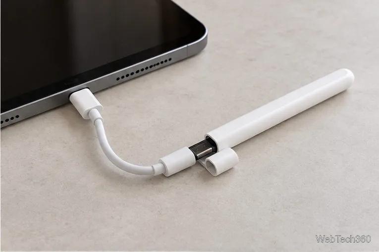 Apple Pencil (USB-C), подключенный к iPad через зарядный кабель USB-C.